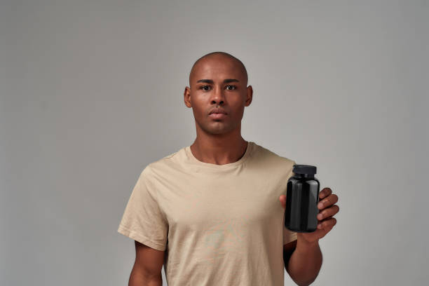 istock Man making a promotion of a black bottle 1297672719