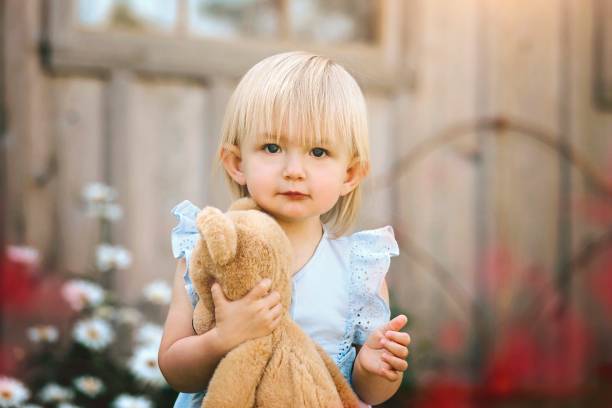 istock Baby Girl With Teddy Bear Outside 1297673428