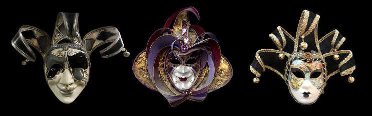 Venetian carnival mask and garland on the black textile background. Top view. Close-up. Holiday background.