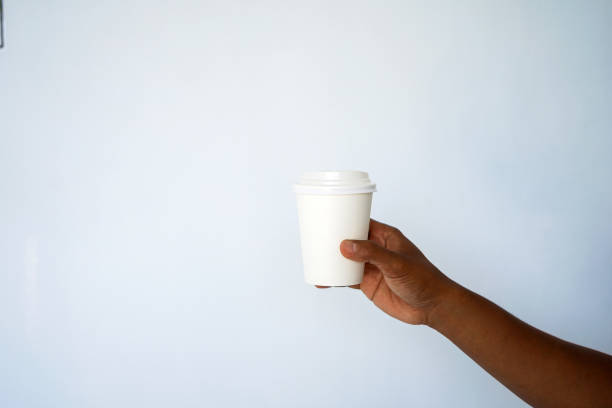 istock The hand of a dark-skinned man holds a disposable cup for coffee 1297674487