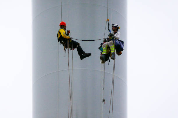 istock Two rope access technicians connected by rope rappelling down from wind turbine on the ropes, doing paint inspection of tower 1297674519