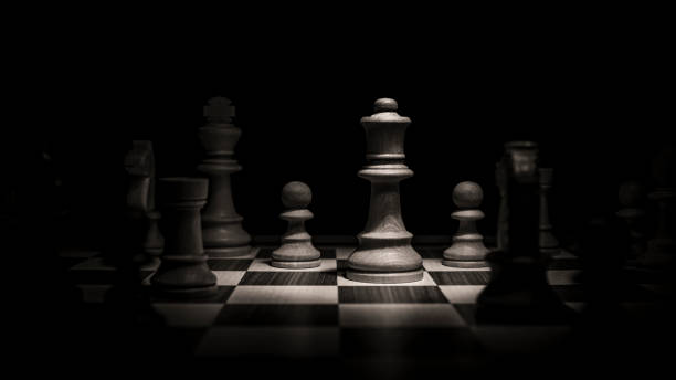 Queen fighting on the chessboard - Chess pieces Low-key concept picture taken in studio and concerning decision making and strategy. chess rook stock pictures, royalty-free photos & images