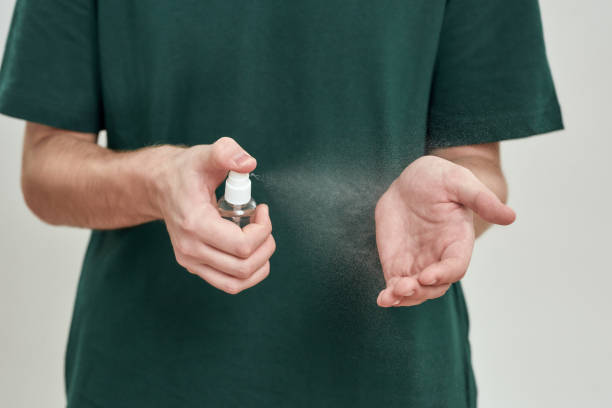 istock Sparying sanitizer on young man hands 1297676897