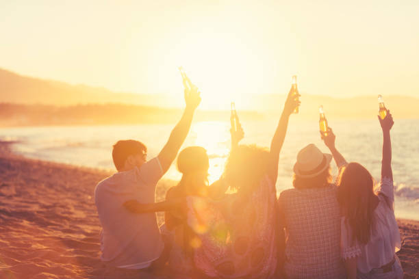 istock Group of young people partying on the beach at sunset. 1297679201
