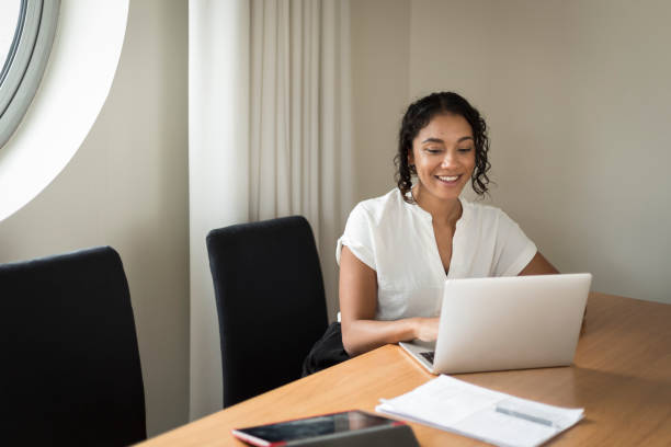 istock Happy young woman working on a laptop in an office 1297679876