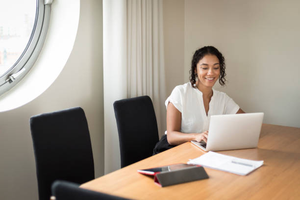 istock Happy young woman working on a laptop in an office 1297679885