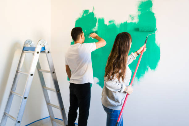 istock Couple in love using a paintbrush and paint roller 1297682494