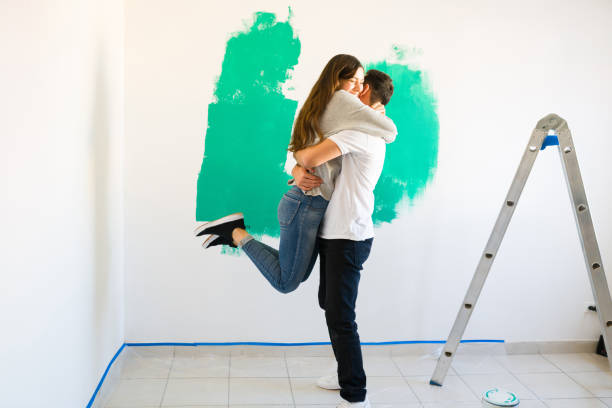 istock Excited couple hugging while redecorating a room 1297682567