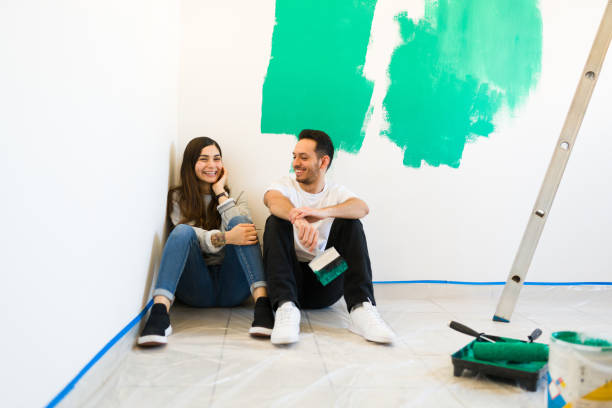 istock Young woman and man flirting while painting a wall 1297682621