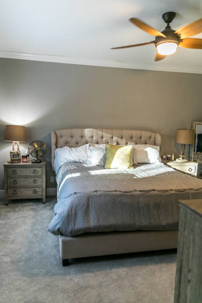 istock Spacious beige carpeted master bedroom with king sized bed 1297682695