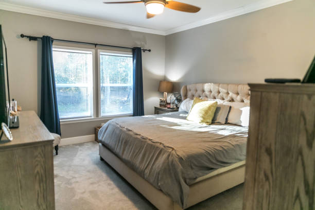istock Spacious beige carpeted master bedroom with king sized bed 1297683274