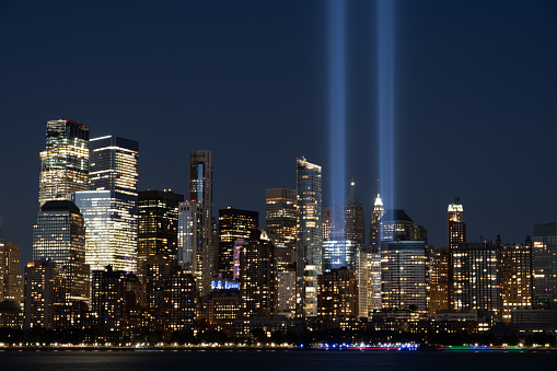 New York, New York - September 11, 2020: A view of the memorial lights rising above the lower Manhattan Island cityscape.