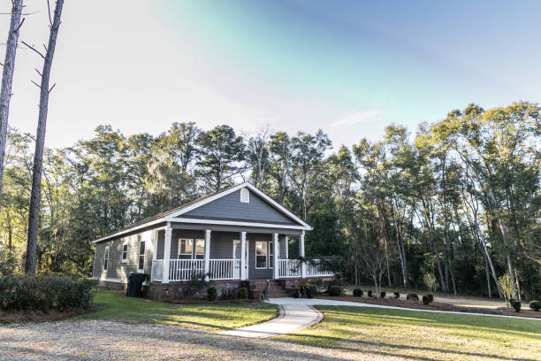 istock Small blue gray mobile home with a front and side porch with white railing. 1297687107