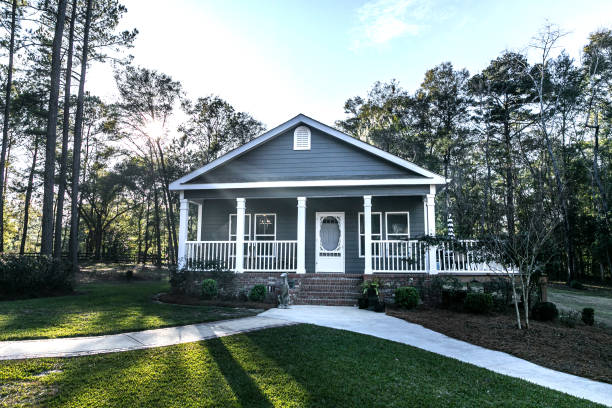 istock Small blue gray mobile home with a front and side porch with white railing 1297689904