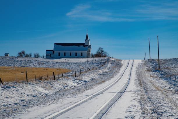 Old church and road on snowy road in western prairie.
