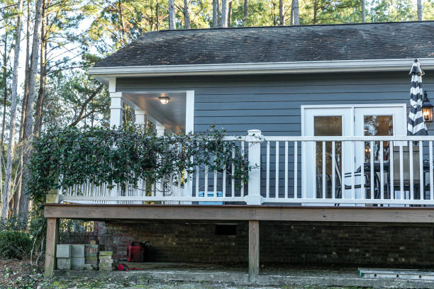 istock Side of small blue gray mobile home with a front and side porch with white railing 1297691430