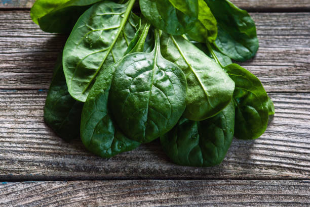 istock Spinach leaves on wooden table, closeup 1297693357