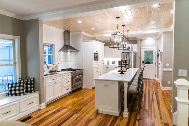 istock Large renovated white kitchen with textured subway tile, black iron lights and pine hardwood flooring 1297693366
