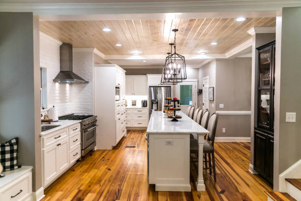 istock Large renovated white kitchen with textured subway tile, black iron lights and pine hardwood flooring 1297694058