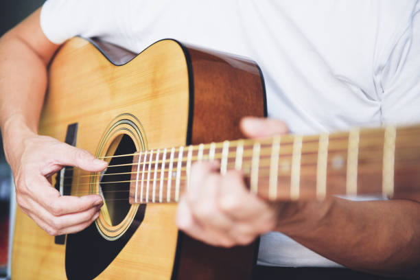 istock Man hands playing acoustic guitar, close up guitar player. 1297700846