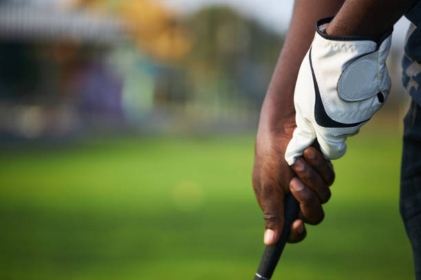 Golfer's hand holds the golf club in preparation for the hit. Golfer's hand holds the golf club in preparation for the hit. golf glove stock pictures, royalty-free photos & images