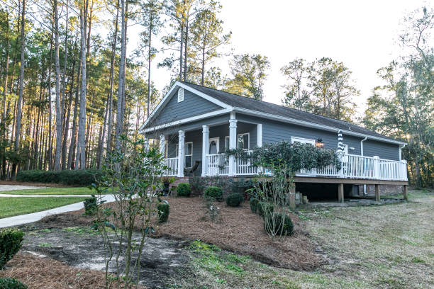 istock Small blue gray mobile home with a front and side porch with white railing 1297702445