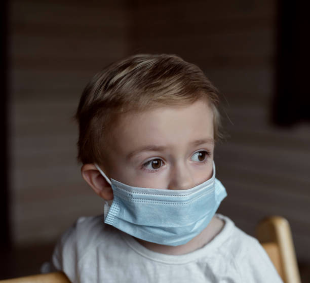 istock a boy sitting in a medical mask 1297705742