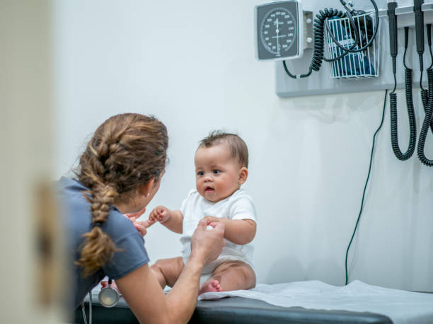 istock Baby sitting on examination table at medical office 1297708768