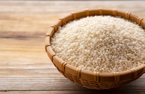 istock Glutinous rice in a bamboo colander set against a background of trees with copy space 1297710305