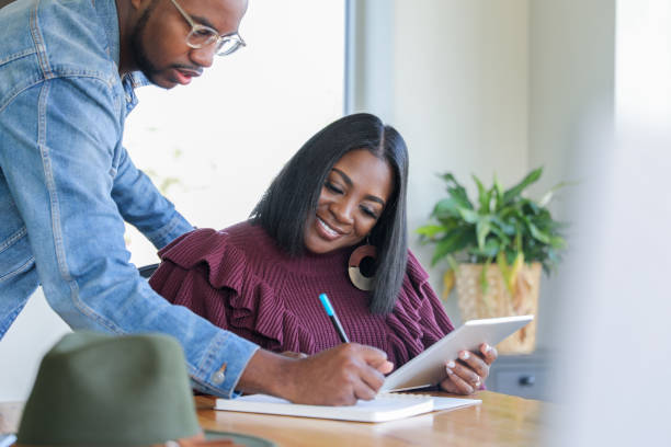 istock Businesswoman holding digital tablet while business partner takes notes 1297711896