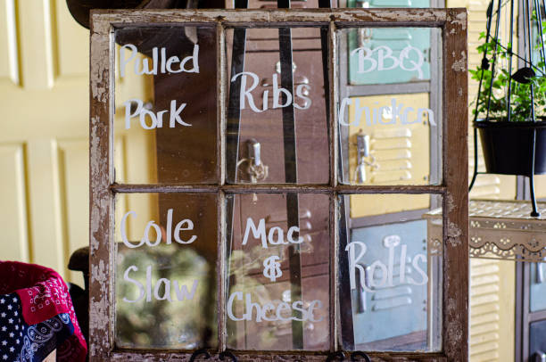 istock Window pane food menu oferring Pulled pork, ribs, Bbq chicken, cole slaw, mac & cheese, rolls 1297713598