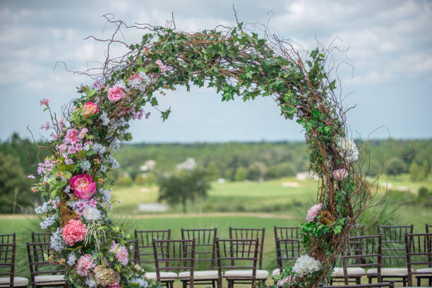 istock Huge round flower altar at wedding ceremony setting  with brown chiavari chairs and white cushions 1297713656
