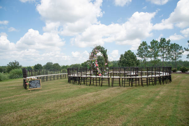 Unique round spiral chair pattern wedding ceremony setting at rolling hills countryside with brown chiavari chairs and white cushions