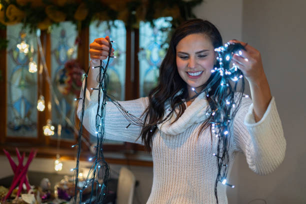 istock Woman decorating house with christmas lights 1297717477