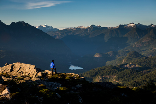 Male hiker looking at views from top of mountain. Sunshine Coast, BC, Canada. Sunshine Coast Trail.