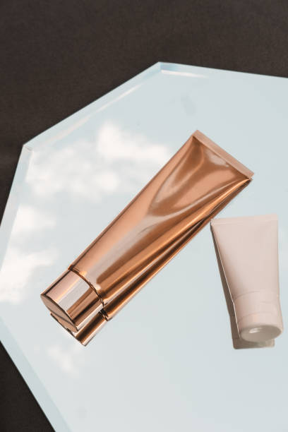 istock White and gold cosmetic product on mirror minimal 1297720742