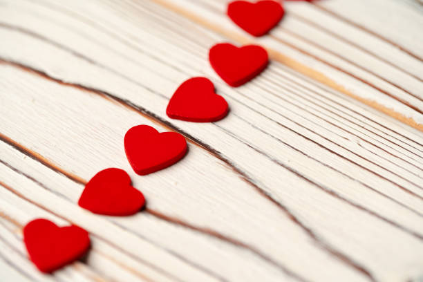 istock Red paper hearts on wooden background close up 1297721569