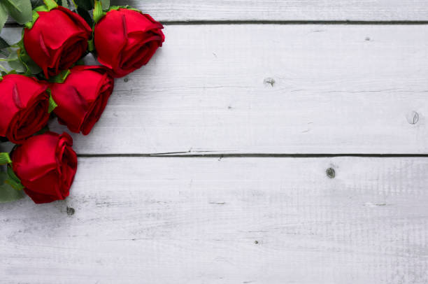 istock Red roses on white wood background with copy space for text for Valentine and wedding frame concept 1297722352