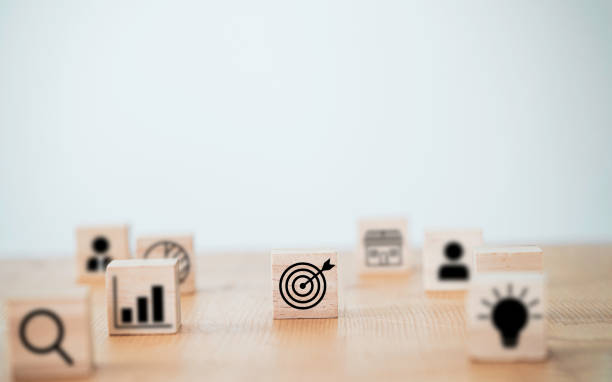 istock Target board with arrow print screen on wooden cube block to setup objective target and investment goal. 1297722485