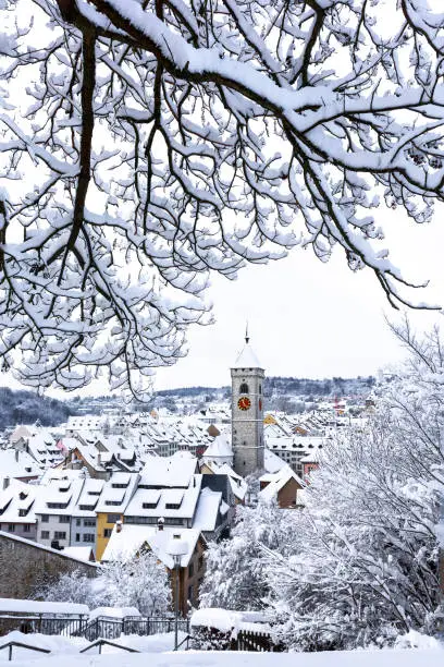 The St. Johan church tower over the old town roofs after a winter snow fall, Schaffhausen, Switzerland