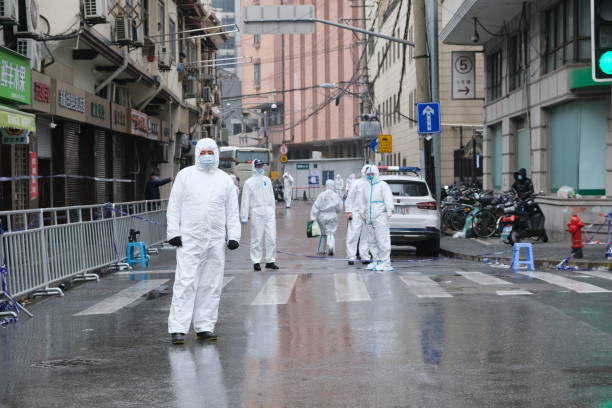 medical staff in white hazmat suit on street in china - china covid imagens e fotografias de stock