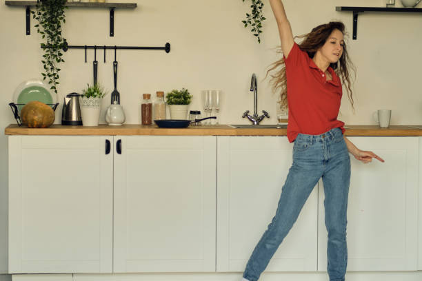 istock Dancing and singing while cooking uses the pilgrim as a microphone, a cheerful, energetic, joyful attitude to household chores 1297731428
