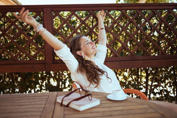 istock happy modern woman sitting at table with raised arms rejoicing 1297734120