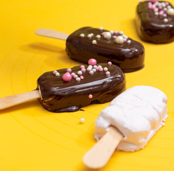 istock Marshmallow on a stick in the form of a popsicle covered with chocolate and without. Selective focus. 1297736387