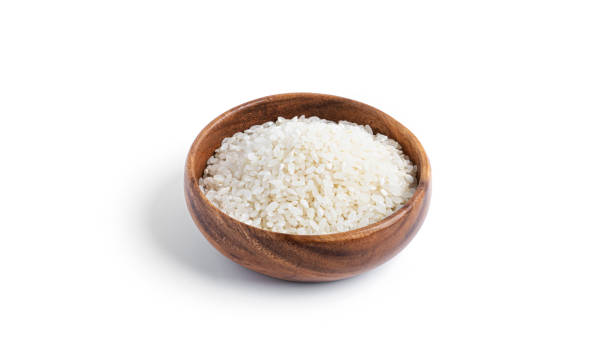 istock Rice in a wooden bowl isolated on a white background 1297736427