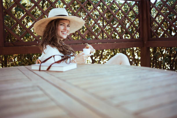 istock happy woman in shirt sitting at table drinking coffee 1297736529