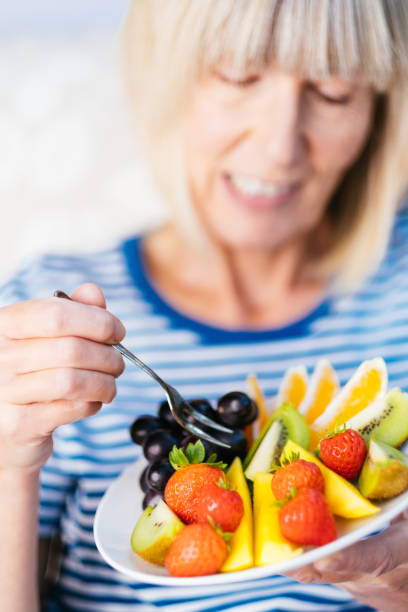 istock Attractive senior woman with fruit lunch 1297736747