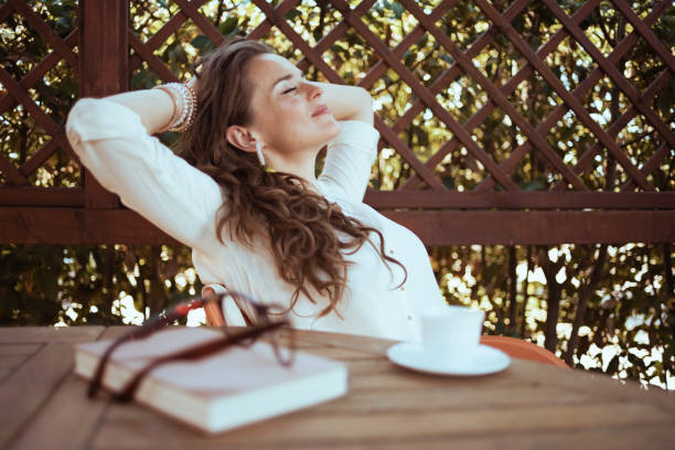 relaxed housewife in white shirt sitting at table
