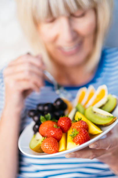 istock Attractive senior woman with fruit lunch 1297737721