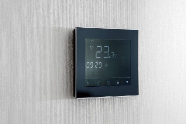 istock Modern wireless thermostat installed on the white wall at home. Smart home heating regulation concept 1297738710